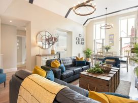 A living room with a sofa and coffee table at Juniper Cottage