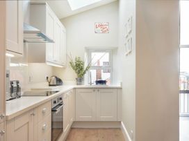A kitchen with cabinets and appliances at Juniper Cottage