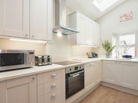 A kitchen with cabinets and appliances at Juniper Cottage