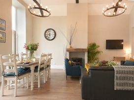 A living room with a dining area and a fireplace at Juniper Cottage