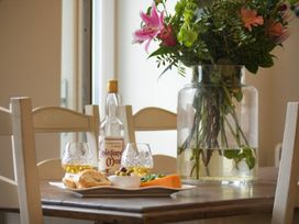 A dining room table with food and drinks at Juniper Cottage