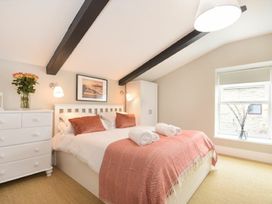 A bedroom with a bed and dresser at Juniper Cottage