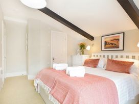 A bedroom with a bed and dresser at Juniper Cottage