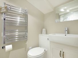 A bathroom with a sink, toilet, and towel rail at Juniper Cottage
