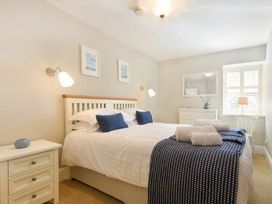 A bedroom with a bed and nightstand at Juniper Cottage