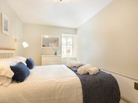 A bedroom with a bed and dresser at Juniper Cottage