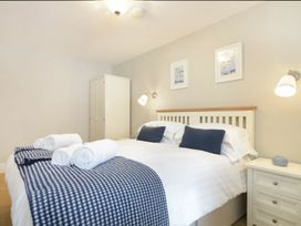 A bedroom with a bed, nightstand, and wardrobe at Juniper Cottage in 