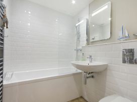 A bathroom with a bathtub, sink, and shower at Juniper Cottage