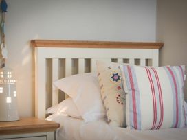 A bed with pillows and a lamp at Juniper Cottage