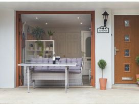 An outdoor seating area with a couch, table, and plants at Juniper Cottage