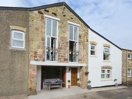 An outdoor area with stone exterior and balcony at Juniper Cottage
