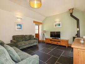 A living room with a sofa and television at Little Trethellan in Trethellan near Lanner