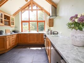 A kitchen with wooden cabinets and a marble countertop at Little Trethellan near Lanner