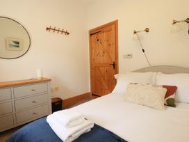 A bedroom with a bed and dresser at Little Trethellan in Trethellan near Lanner
