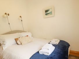 A bedroom with a bed and bedside lamps at Little Trethellan near Lanner