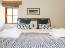 A bedroom with a bed and pillows at Little Trethellan in Trethellan near Lanner