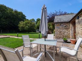 An outdoor seating area with a table and chairs at Little Trethellan in Trethellan near Lanner