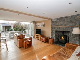 A living room with furniture and glass doors to the garden at Awelon Y Mor Aberaeron