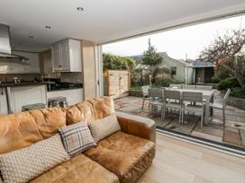 A dining room with a sofa and a view of the garden at Awelon Y Mor in Aberaeron