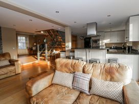 A living room with a sofa and staircase at Awelon Y Mor Aberaeron