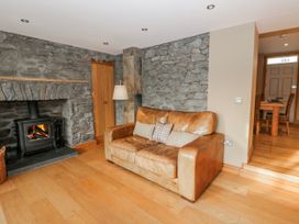 A living room with a sofa and fireplace at Awelon Y Mor in Aberaeron