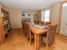 A dining room with a large table and chairs at Awelon Y Mor Aberaeron