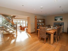 A dining room with a wooden table and chairs at Awelon Y Mor, Aberaeron