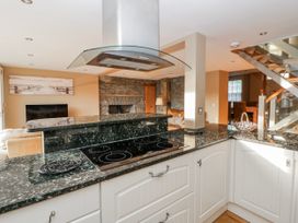 A kitchen with a stove and kitchen island at Awelon Y Mor in Aberaeron