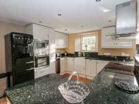 A kitchen with black appliances and granite countertops at Awelon Y Mor in Aberaeron