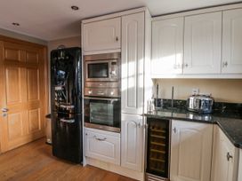 A kitchen with appliances and cabinets at Awelon Y Mor Aberaeron
