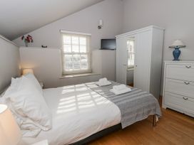 A bedroom with a bed and wardrobe at Awelon Y Mor Aberaeron