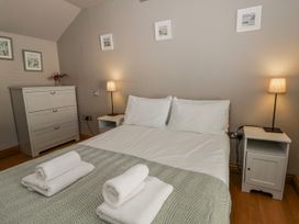 A bedroom with a bed and nightstands at Awelon Y Mor in Aberaeron