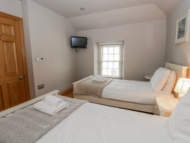A bedroom with two beds and a television at Awelon Y Mor in Aberaeron
