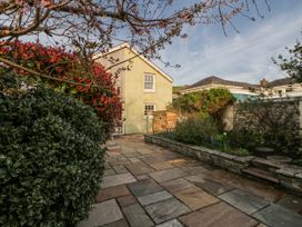 A garden featuring a house and paved stones at Awelon Y Mor in Aberaeron