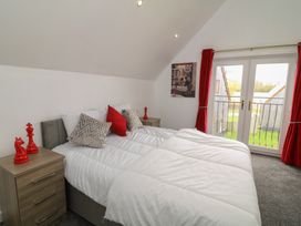 A bedroom with a bed and nightstands at Ruby Red in Brigg