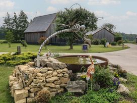A sculpture of a dragonfly near a pond with plants at Ruby Red in Brigg