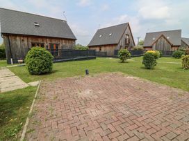 Outdoor area with wooden houses and shrubs at Ruby Red in Brigg