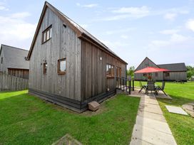 A wooden house with a garden and patio at Ruby Red near Brigg