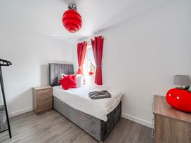 A bedroom with a bed, nightstand, and curtains at Ruby Red near Brigg