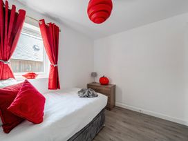 A bedroom with a bed and red curtains at Ruby Red near Brigg