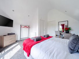 A bedroom with a bed, TV and dresser at Ruby Red Near Brigg