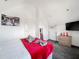 A bedroom with a bed, television, and dresser at Ruby Red near Brigg