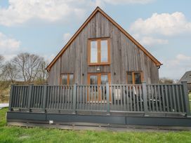 A house with a deck and windows at Pumpkin Lodge in Brigg