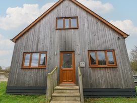 A house with a wooden exterior and a front door at Poker Lodge in Brigg
