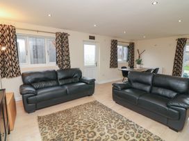 A living room with sofas and a table at Poker Lodge in Brigg