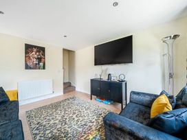 A living room with a TV and couches at Poker Lodge near Brigg