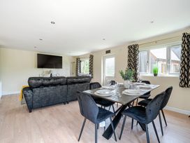 A living room with a sofa and dining table at Poker Lodge Near Brigg