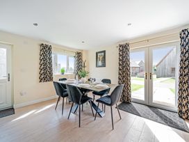 A dining room with a table and chairs at Poker Lodge Near Brigg