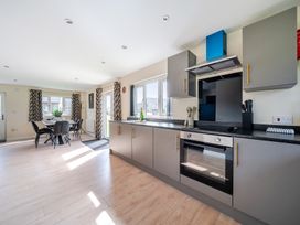 A kitchen with cabinets and a dining area at Poker Lodge Near Brigg