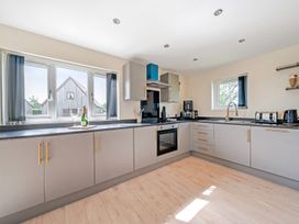 A kitchen with various appliances and windows at Poker Lodge Near Brigg